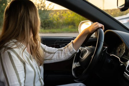 Junge Frau parkt bei Sonnenuntergang mit Auto auf der Autobahn Womandriver sucht Hilfe. Geschäftsfrau treibt Konzept voran