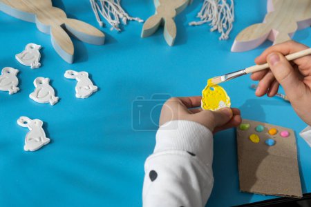 Master class of coloring Creator is using white air dry clay for making decor to EASTER holiday. Creating hobby recreation activity that involves fingers. DIY crafting Modern art 