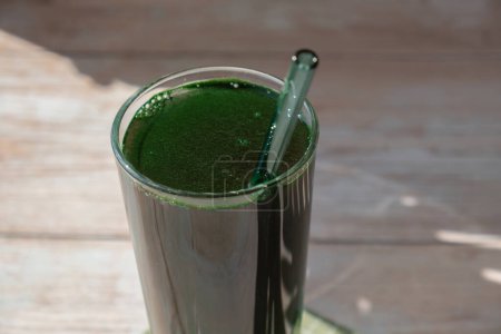 Natural organic green spirulina algae powder drink on neutral beige background. Chlorella seaweed vegan superfood cocktails smoothie supplement source and detox drinking. Innovative ingredient