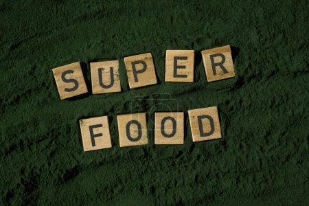 Holzblöcke mit Text SUPERFOOD chlorella auf dem Hintergrund von Algen Superfood-Pulver. Gesunder Nutzen Ergänzung und veganes Antioxidans gesundes Ernährungskonzept 