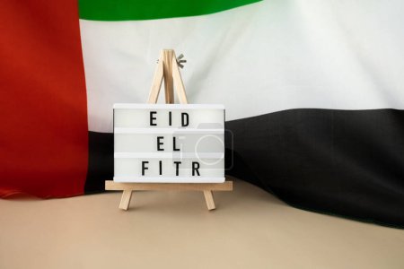 Message Lightbox EID EL FITR - Eid Mubarak - Marco de texto de Happy Holidays en Emiratos Árabes Unidos ondeando bandera de material de seda. Fondo de celebración festiva pública. La Bandera Nacional de los EAU