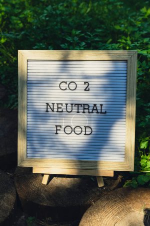 CO2 NEUTRAL FOOD Nachricht auf dem Hintergrund der frischen umweltfreundlichen biologisch angebauten grünen Kräuterpetersilie im Garten. Konzept zur Nahrungsmittelproduktion auf dem Land. Ernten vor Ort. Nachhaltigkeit und Verantwortung 
