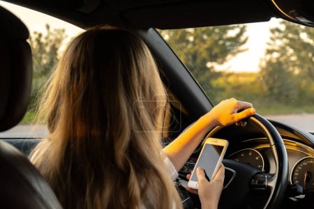 Womandriver mit Handy zahlen für das Parken und Navigieren in der Stadt, während am Straßenrand angehalten. Selbstfahrendes Roadtrip, Technologie, Reisen und Menschen-Konzept