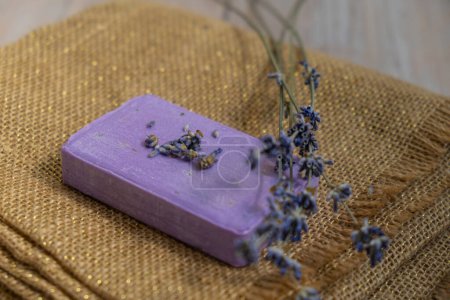 Lavender soap on fabric background with copy space for your text. Advertisement template mock up. Skincare homemade natural cosmetic concept. Organic dry lavender flower. Handmade soap 