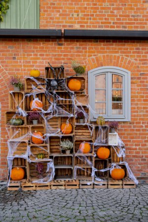 Halloween fall decorated outdoor cafe or restaurant terrace in America or Europe with pumpkins autumn flowers traditional attributes of Halloween. Frontyard decoration for party. 