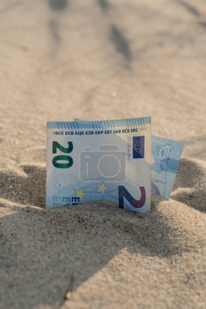 Photo for Money 20 euros bills in sandy beach. Concept finance saving money for holiday vacation. Costs in travel holidays. Shadows - Royalty Free Image