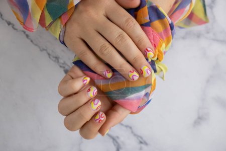 Pastel softness colorful manicured nails. Woman showing her new summer manicure in colors of pastel palette. Simplicity decor fresh spring vibes earth-colored neutral tones design