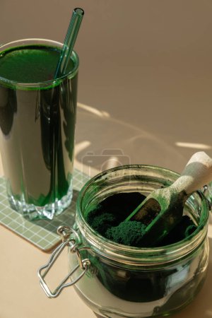 Bebida en polvo de algas Espirulina verde orgánica natural sobre fondo beige neutro. Clorella algas veganas superalimentos cócteles smoothie fuente suplemento y desintoxicación de beber. Ingrediente innovador