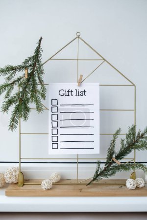 Photo for Preparation for winter holidays. GIFT LIST text on paper note. Celebration gifts and presents preparing Natural zero waste homemade Christmas decor. Happy new year concept. - Royalty Free Image