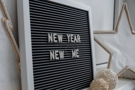 Photo for NEW YEAR NEW ME text on black letter board with cozy minimalistic handmade Christmas decor. New year aims resolutions. Low key festive Planning and setting goals concept - Royalty Free Image