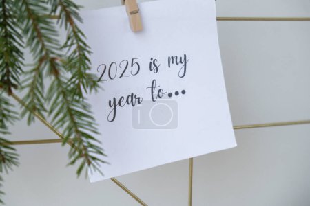 Photo for 2025 IS MY YEAR TO text on white paper note on vision board with Christmas decor. New year aims resolutions. New me you concept visualizing dreams - Royalty Free Image