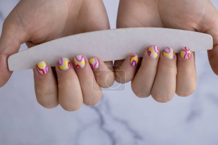 Herramientas de manicura Mujer manicura manos, elegante verano uñas de colores. Primer plano de las uñas cuidadas de la mano femenina. Estilo de verano del concepto de diseño de uñas. Tratamiento de belleza.