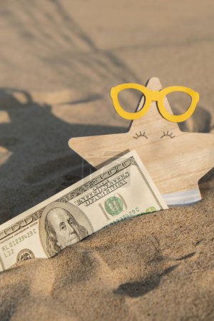 Photo for Money american hundred dollar bills in sandy beach with starfish. Concept finance saving money for holiday vacation. Costs in travel holidays. Shadows - Royalty Free Image