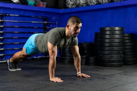 Photo for Latin man with sportswear doing high plank in a crossfit gym - Royalty Free Image
