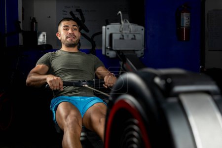 Photo for Close up of a man rowing on a machine in a crossfit gym - Royalty Free Image