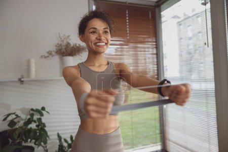 Foto de Mujer afroamericana haciendo ejercicios para las manos por tutoriales en línea en el ordenador portátil en casa - Imagen libre de derechos