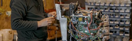 Téléchargez les photos : Électricien masculin réparant machine à café dans l'atelier. Photo de haute qualité - en image libre de droit