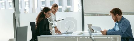 Photo for Female boss shows something in notebook to employee during working day in office. High quality photo - Royalty Free Image