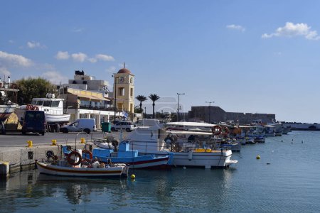 Foto de Ierapatra, Creta, Grecia - 12 de octubre de 2022: Barcos de pesca y edificios en el puerto de la ciudad más meridional de Europa en el mar libio con la antigua fortaleza veneciana Kales en el fondo - Imagen libre de derechos