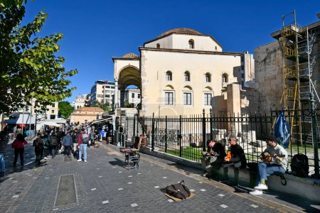 Photo for Athens, Greece - December 19, 2023: Unidentified people and street musicians on Monastiraki square with the small Byzantine church former known as Panagia Pantanasa The Athenian and Tzisdaraki Mosque, now used as Museum of Modern Greek Culture - Royalty Free Image