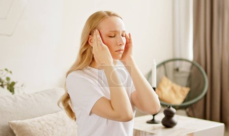 La mujer malsana estresada que se siente cansada tiene un dolor de cabeza fuerte y terrible. Mujer sufriendo de migraña masaje templos.