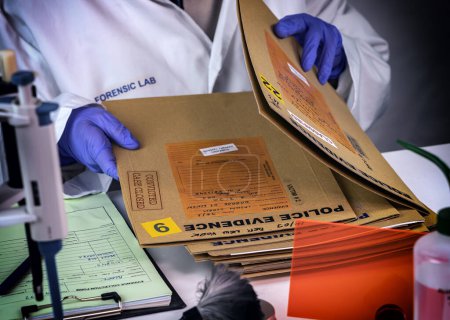 Foto de Experto en policía guardado en una caja de registros y pruebas de un caso de asesinato en el laboratorio científico - Imagen libre de derechos