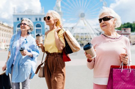 Téléchargez les photos : Belles femmes âgées heureuses se réunissant à l'extérieur et faisant du shopping dans le centre-ville - Jolies et joyeuses vieilles femmes adultes se lient et s'amusent à l'extérieur - en image libre de droit