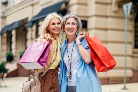 Schöne fröhliche Seniorinnen treffen sich im Freien und shoppen in der Innenstadt - Schöne und fröhliche alte erwachsene Frauen verbinden sich und haben Spaß im Freien