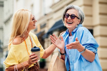 Téléchargez les photos : Belles femmes âgées heureuses se réunissant à l'extérieur et faisant du shopping dans le centre-ville - Jolies et joyeuses vieilles femmes adultes se lient et s'amusent à l'extérieur - en image libre de droit