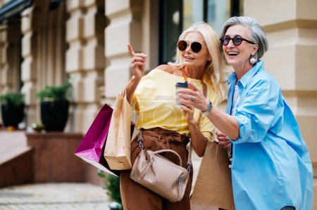 Schöne fröhliche Seniorinnen treffen sich im Freien und shoppen in der Innenstadt - Schöne und fröhliche alte erwachsene Frauen verbinden sich und haben Spaß im Freien
