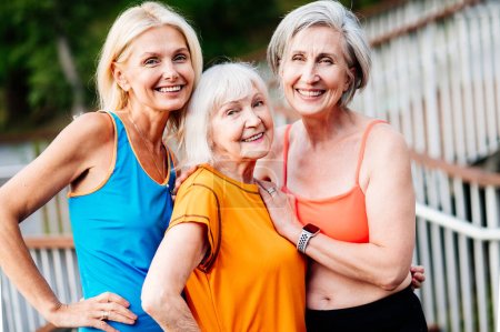 Photo for Group of beautiful sportive senior women training outdoors - Mature adults old friends doing fitness workout exercises in a park to stay healthy and fit - Royalty Free Image