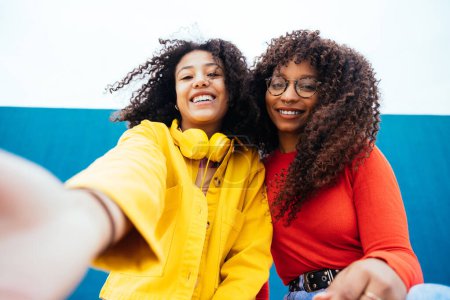 Foto de Jóvenes mujeres felices tomando selfies con el smartphone. Adolescentes divirtiéndose al aire libre después de la escuela - Imagen libre de derechos