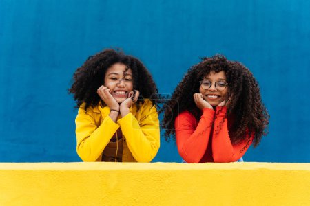 Photo for Young happy women smiling and having fun outdoor. Teenager girls with curly hair posing and making happy face expressions in front the camera - Royalty Free Image