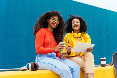 Foto de Jóvenes mujeres felices estudiando en un dispositivo de tableta. adolescentes pasar tiempo juntos después de la escuela - Imagen libre de derechos