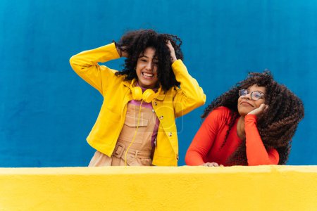 Photo for Young happy women smiling and having fun outdoor. Teenager girls with curly hair posing and making happy face expressions in front the camera - Royalty Free Image