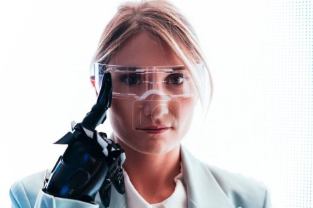Téléchargez les photos : Femme d'affaires avec bras bionique cyborg et visière de réalité augmentée. Représentation de l'avenir qui inclura l'être humain et les parties technologiques - aspect cyberpunk - en image libre de droit