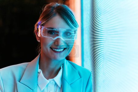 Foto de Mujer de negocios con brazo biónico cyborg y visor de realidad aumentada. Representación del futuro que incluirá el ser humano y las partes tecnológicas - aspecto ciberpunk - Imagen libre de derechos