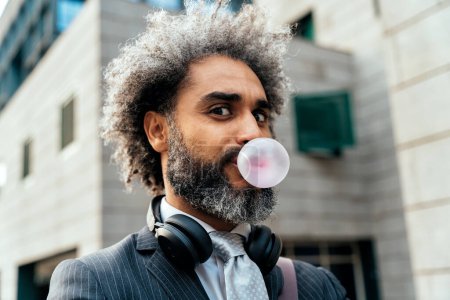 Téléchargez les photos : Jeune entrepreneur mâcher de la gomme à bulles de fruits et faire des ballons - en image libre de droit