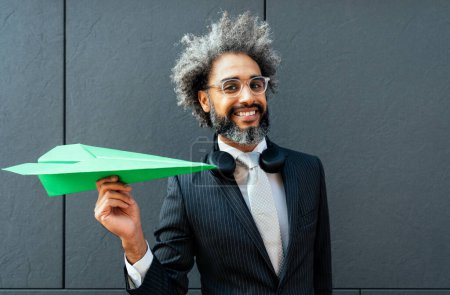 Das filmische und erzählerische Bild eines jungen Unternehmers, der ein Flugzeug aus grünem Papier in die Luft wirft. Konzeptionelle Darstellung grüner Energie- und Technologievorstellungen