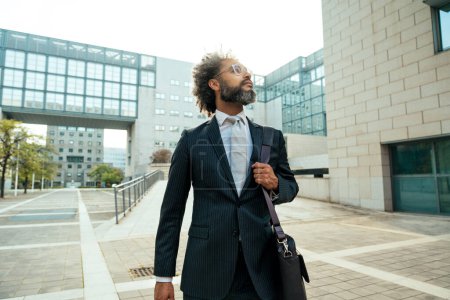 Foto de Joven empresario hombre de negocios caminando fuera de su oficina después de un ajetreado día de trabajo exitoso - Imagen libre de derechos