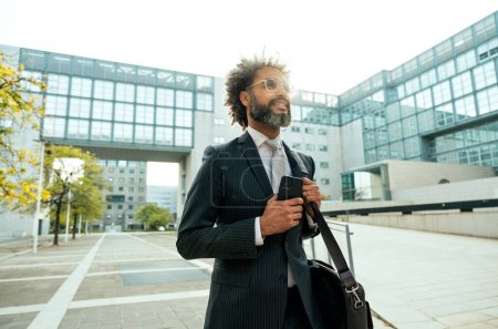 Foto de Joven empresario hombre de negocios caminando fuera de su oficina después de un ajetreado día de trabajo exitoso - Imagen libre de derechos