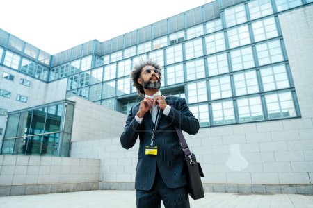 Téléchargez les photos : Jeune entrepreneur homme d'affaires marchant devant son bureau après une journée bien remplie de travail réussi - en image libre de droit