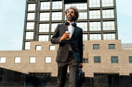 Téléchargez les photos : Jeune entrepreneur homme d'affaires marchant en dehors de son bureau après une longue journée de travail réussie dans l'entreprise en démarrage - en image libre de droit
