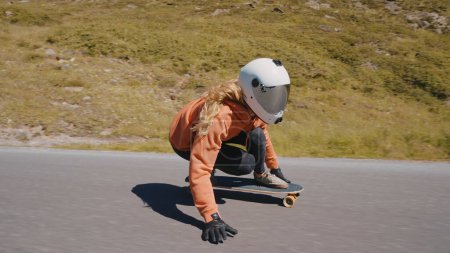 Photo for Cinematic downhill longboard session. Young woman skateboarding and making tricks between the curves on a mountain pass. Concept about extreme sports and people - Royalty Free Image