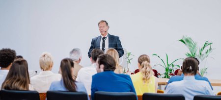 Photo for Cinematic image of a conference meeting. Business people sitting in a room listening to the motivator coach. Representation of a Self growth and improvement special event - Royalty Free Image