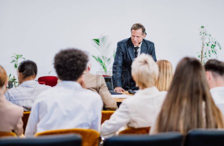 Foto de Imagen cinematográfica de una reunión de conferencias. Gente de negocios sentada en una habitación escuchando al entrenador motivador. Representación de un evento especial de Auto crecimiento y mejora - Imagen libre de derechos