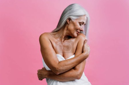 Foto de Imagen de una hermosa mujer mayor posando en una sesión de fotos de belleza. Mujer de mediana edad sobre un fondo de color. Concepto sobre positividad corporal, autoestima y aceptación corporal - Imagen libre de derechos