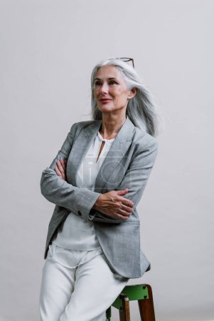 Foto de Hermosa mujer mayor posando en una sesión de fotos de negocios corporativos. Mujer de negocios con traje elegante en fondos de color en el estudio. - Imagen libre de derechos