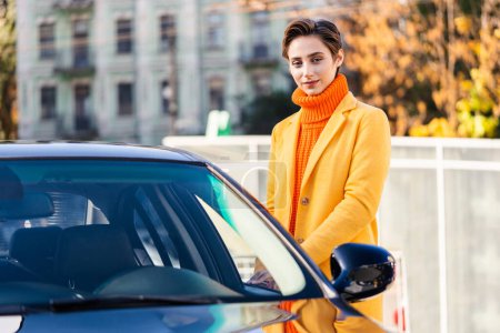 Photo for Beautiful young woman with short hair driving car in the city - Pretty caucasian female adult business woman wearing elegant suit going to work in the office - Royalty Free Image