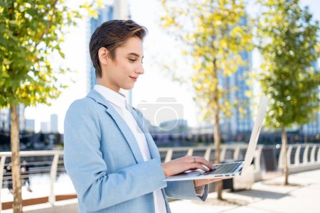 Photo for Beautiful young woman with short hair in the city - Pretty caucasian female adult business woman wearing elegant suit going to work in the office - Royalty Free Image